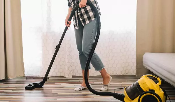 cropped picture of a person vacuuming the floor
