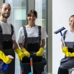 Team of housekeeping staff standing near the window in the office