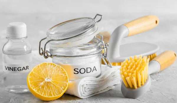 Front view of eco-friendly cleaning brushes with lemon and baking soda vinegar and cloth