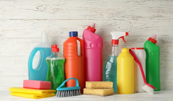 Bottles with detergent and cleaning supplies on wooden