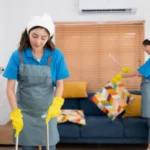 Cleaning service dark haired woman wearing a white hat and yellow gloves cleaning the floor